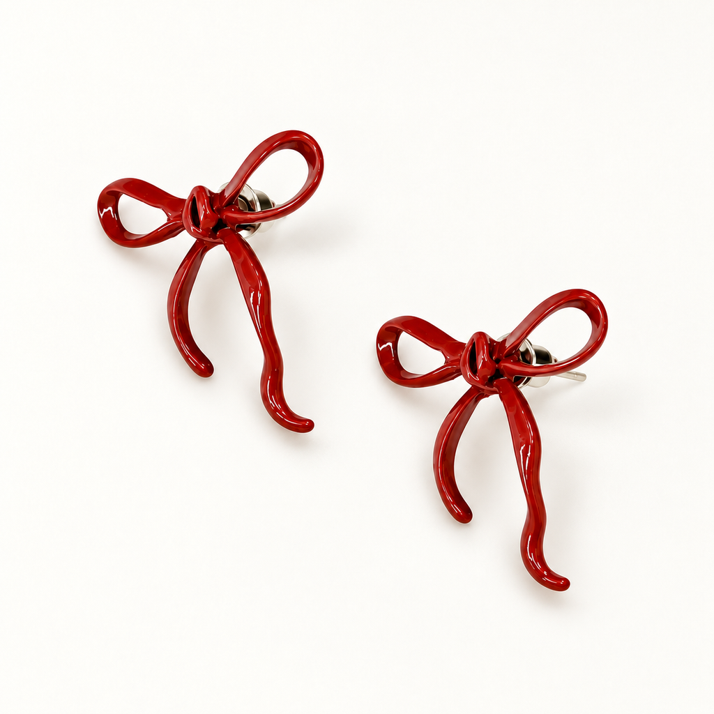A pair of glossy deep-red open-loop bow stud earrings on a clean light background.